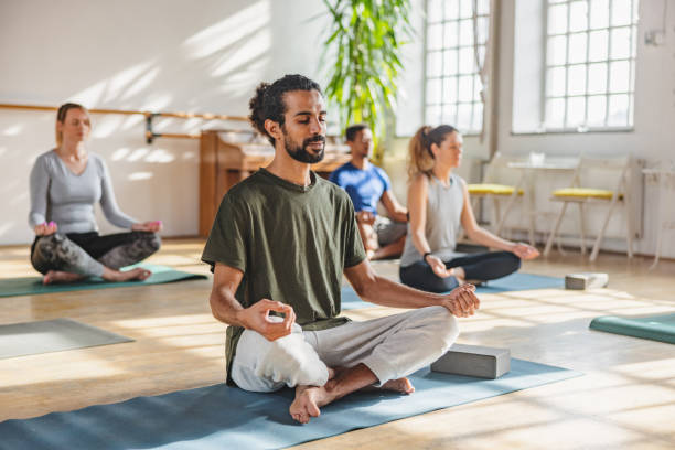 A group practising yoga and meditation outdoors